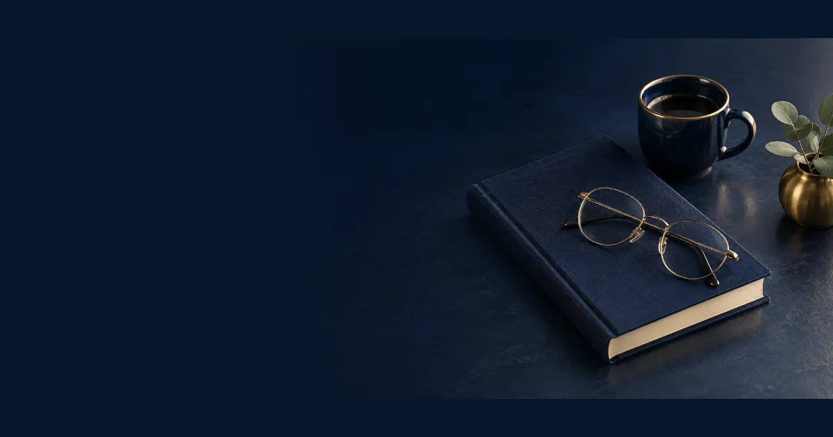 Очки в тонкой оправе на синей книге, рядом чашка